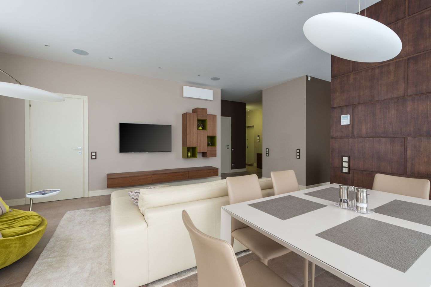 Open-plan living and dining room with a cream sofa and wooden cabinetry